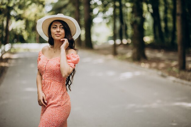 젊은 여자 드레스와 모자 산책 공원에서 입고