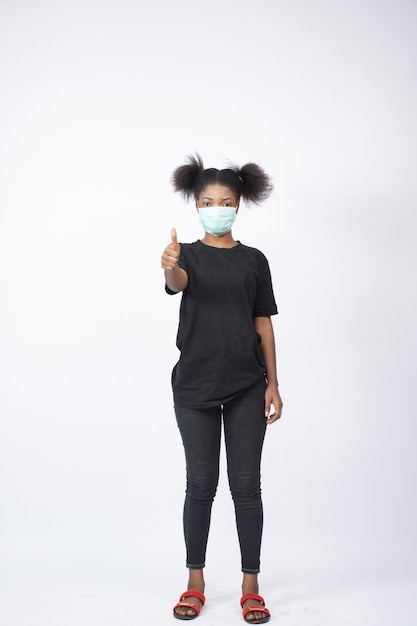 Free photo young woman wearing a face mask, giving a thumbs up