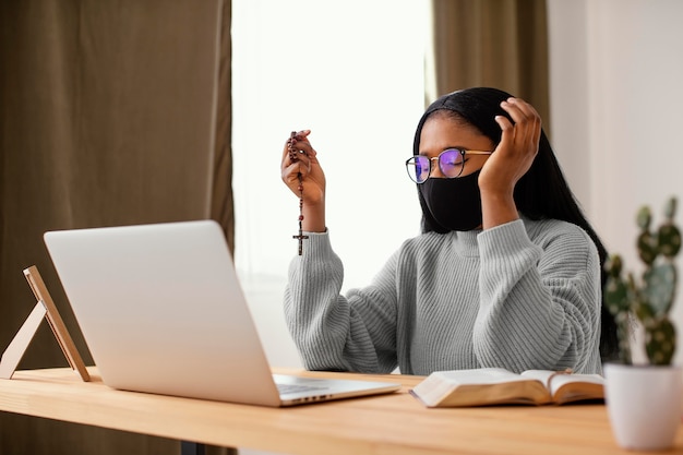 Foto gratuita giovane donna che indossa una maschera per il viso mentre prega