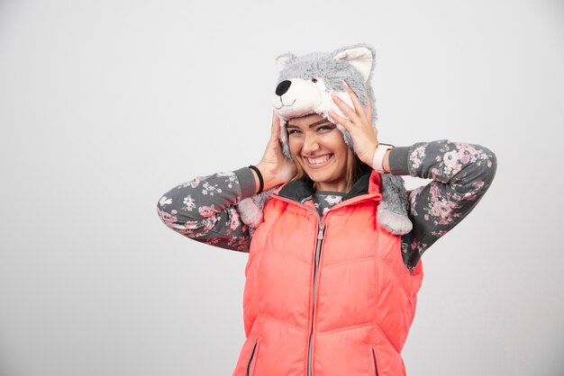 Free photo young woman wearing funny hat on a white wall