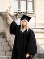 Foto gratuita abito da portare da laurea della giovane donna