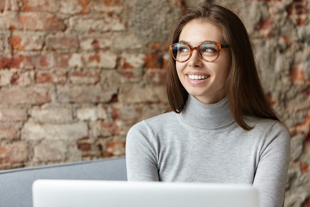 Free photo young woman wearing grey turtleneck and eyeglasses