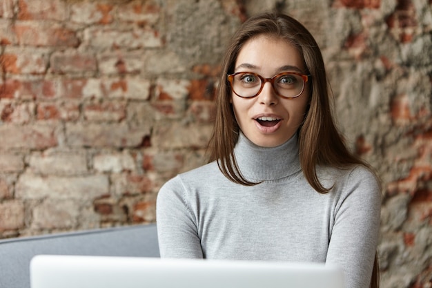 Free photo young woman wearing grey turtleneck and eyeglasses