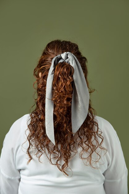 Молодая женщина, носящая платок в качестве аксессуара для волос
