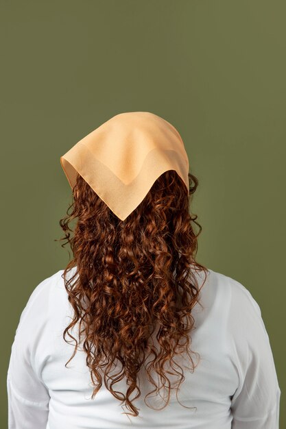Молодая женщина, носящая платок в качестве аксессуара для волос