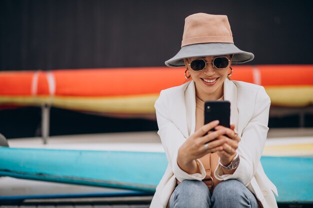 Young woman wearing hat and using phone