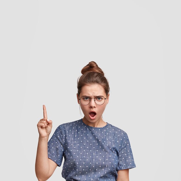 Young woman wearing her hair in a bun and polka dot blouse