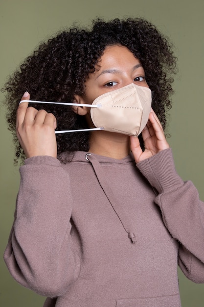 Foto gratuita colpo medio della maschera da portare della giovane donna