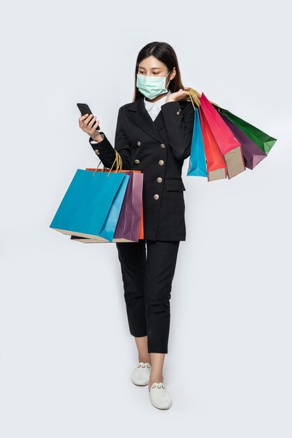 Young woman wearing a mask and shopping on her smartphone