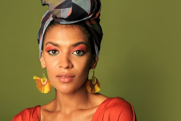 Young woman wearing orange dress with turban and ethnic jewelry