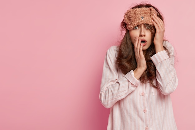 Young woman wearing pajamas and sleep mask