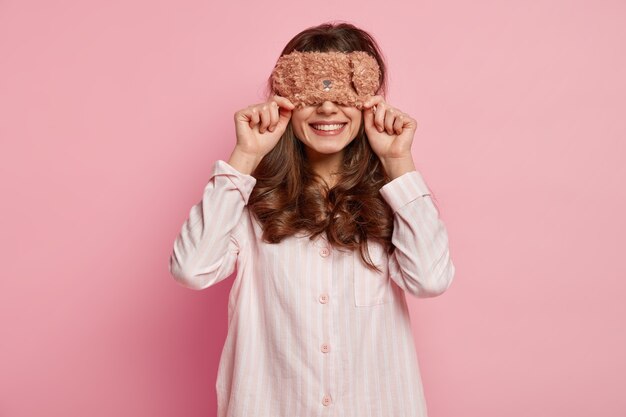 Young woman wearing pajamas and sleep mask