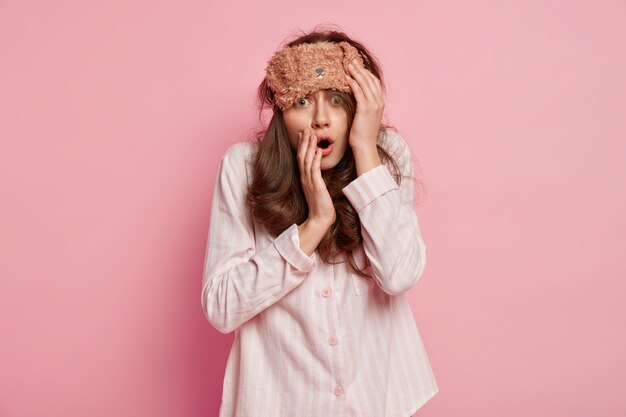 Young woman wearing pajamas and sleep mask