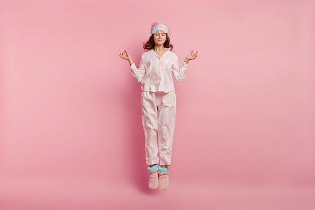 Free photo young woman wearing pajamas and sleep mask