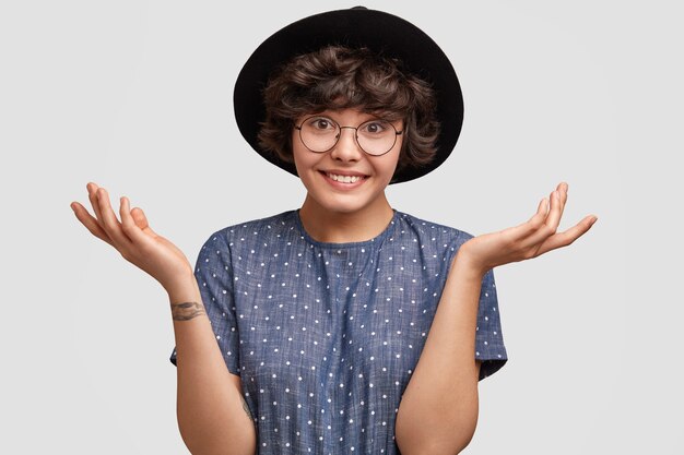 Young woman wearing polka dot blouse and big hat