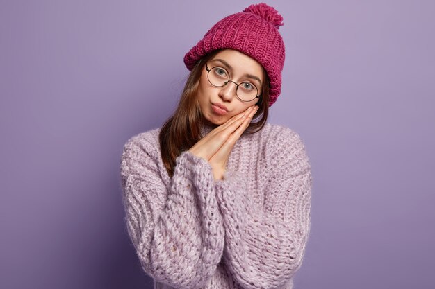 Бесплатное фото Молодая женщина в фиолетовом свитере и шляпе