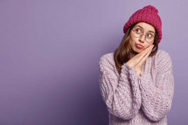 Young woman wearing purple sweater and hat