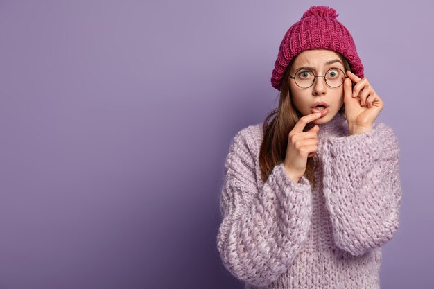 Молодая женщина в фиолетовом свитере и шляпе