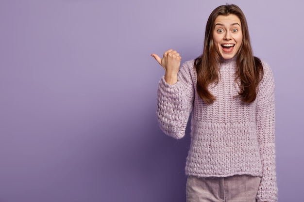 Giovane donna che indossa un maglione viola