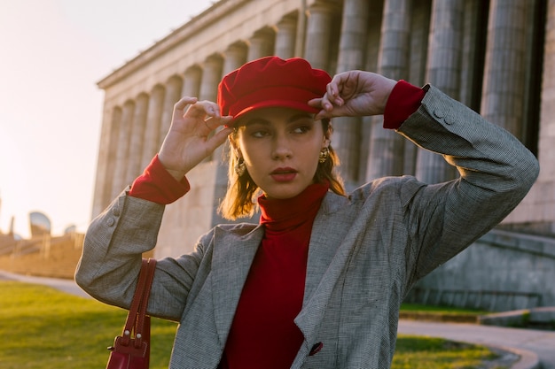 Бесплатное фото Молодая женщина в красной кепке смотрит в сторону