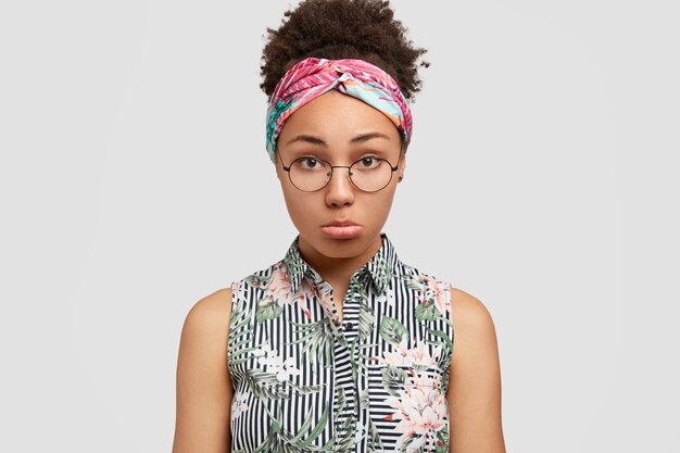 Young woman wearing round eyeglasses and colorful bandana