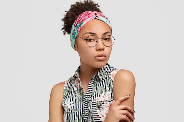 Young woman wearing round eyeglasses and colorful bandana