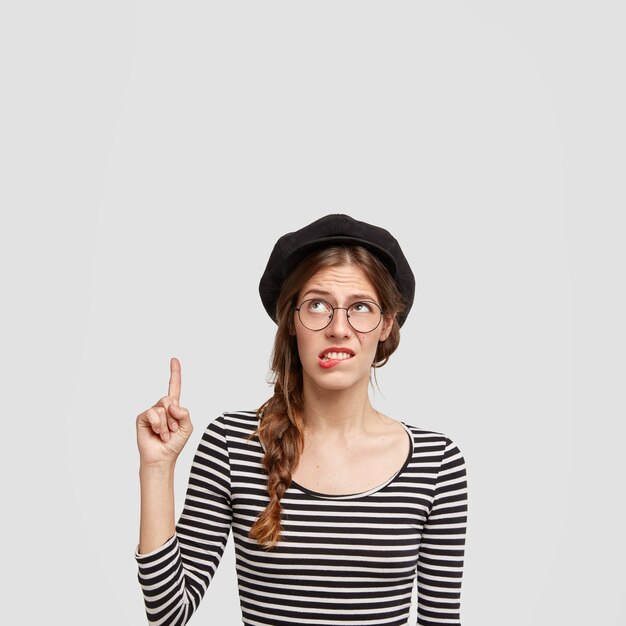 縞模様のシャツとベレー帽を身に着けている若い女性