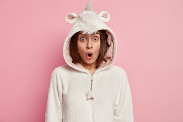 Free photo young woman wearing unicorn pajamas