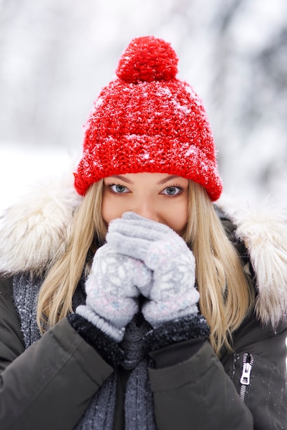 Young woman wearing warm clothes shivering