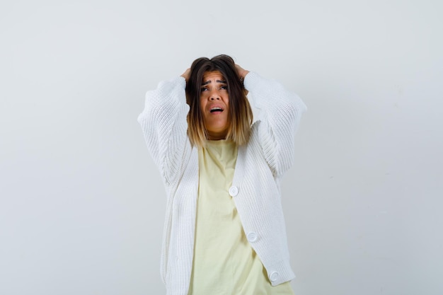 Foto gratuita giovane donna che indossa un cardigan bianco stressata