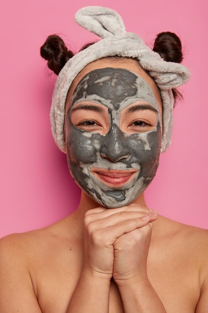 Free photo young woman wears natural facial clay mask skin treatments after taking bath