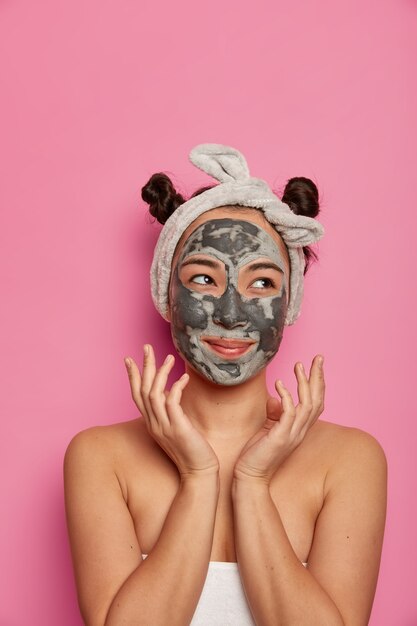 Young woman wears natural facial clay mask skin treatments after taking bath