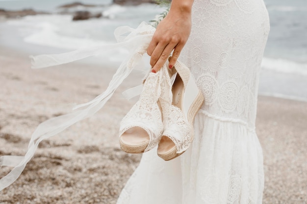 Молодая женщина в свадебном платье на пляже