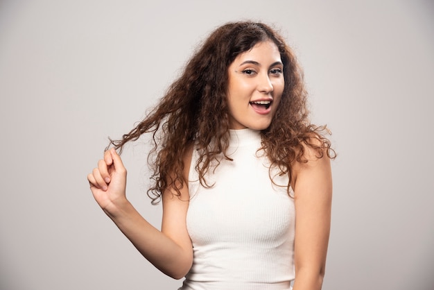 Free photo young woman in white blouse standing over a white wall. high quality photo