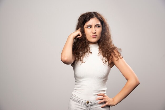 Young woman in white blouse standing over a white wall. High quality photo