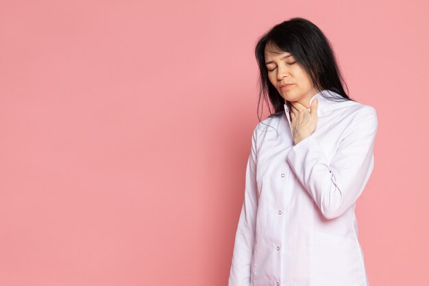 young woman in white medical suit having troubles with her breath on pink