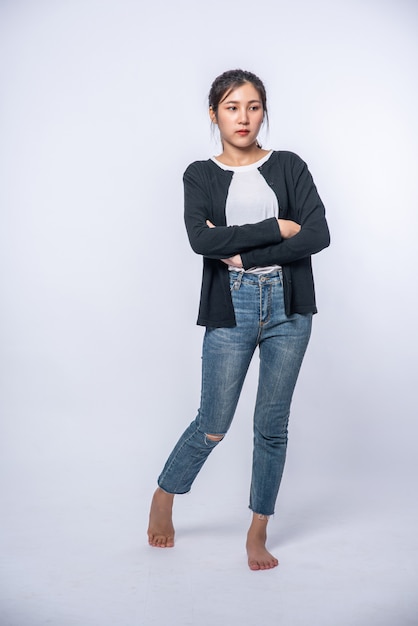 A young woman in a white shirt with arms folded.