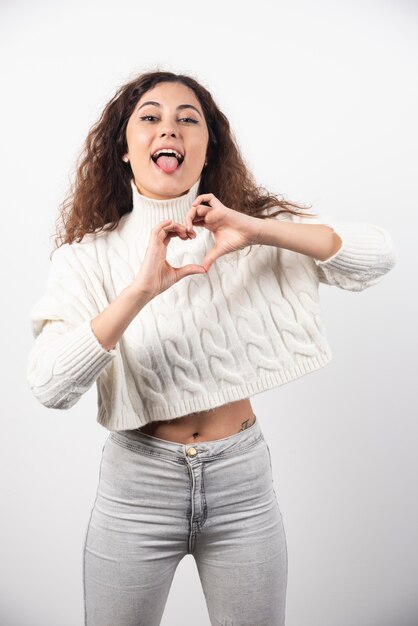 Young woman in white sweater with curly hair posing. High quality photo