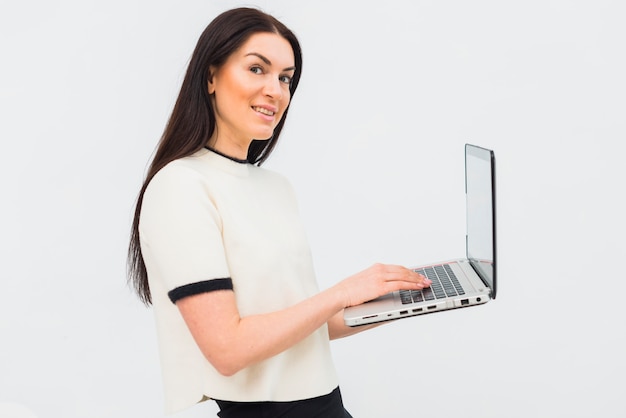 Young woman in white using laptop