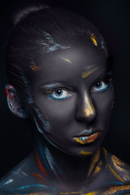 young woman who is posing covered with  black paint