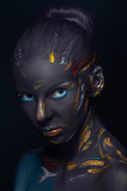 young woman who is posing covered with  black paint