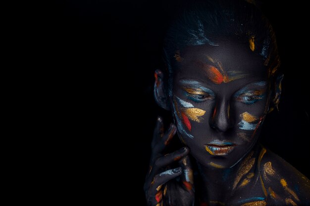 young woman who is posing covered with  black paint