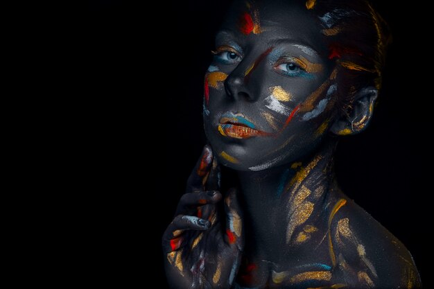 young woman who is posing covered with  black paint