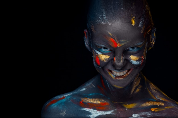 Free photo young woman who is posing covered with  black paint