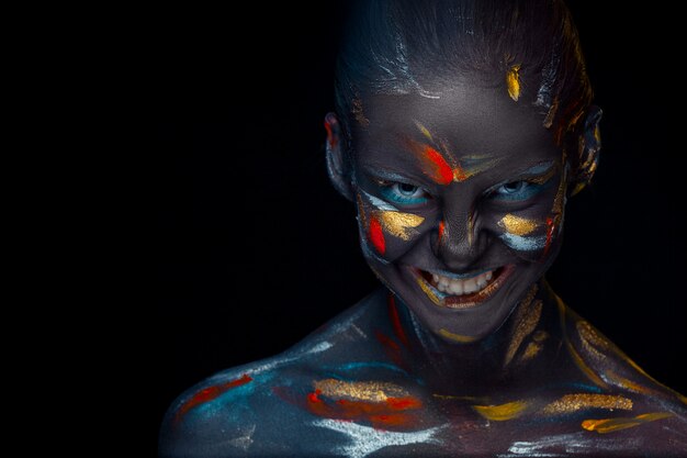 young woman who is posing covered with  black paint