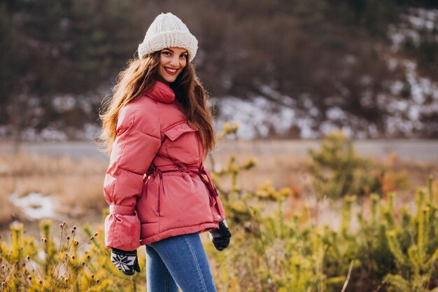 Молодая женщина в зимнем парке счастливым