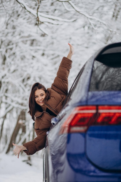 자동차로 여행하는 겨울 시간에 젊은 여자