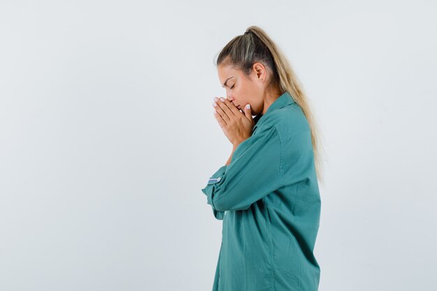 Young woman wishing in blue shirt and looking focused .