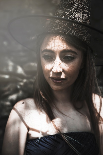 Free photo young woman in witch hat looking aside