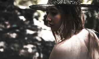 Free photo young woman in witch hat in murk forest